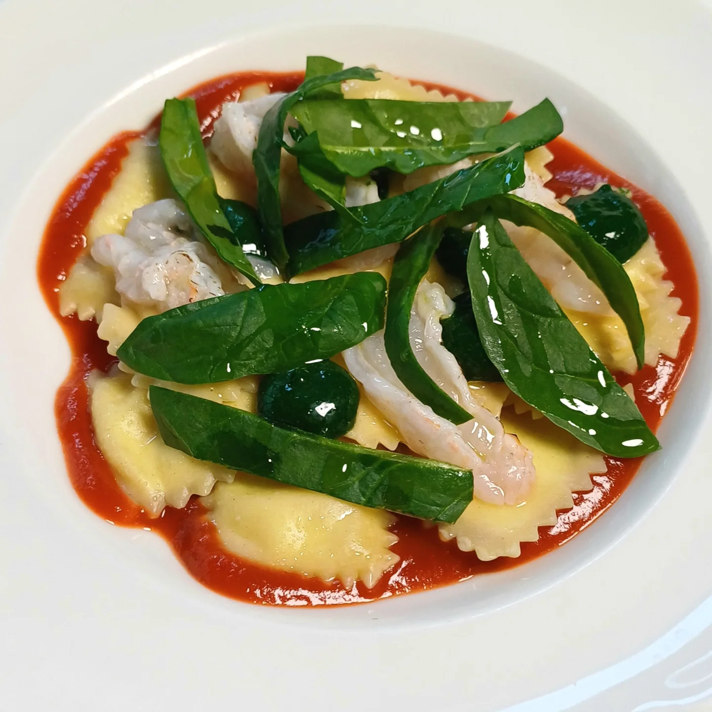 Friske ravioli i tomatsauce med rejer og frisk basilikum